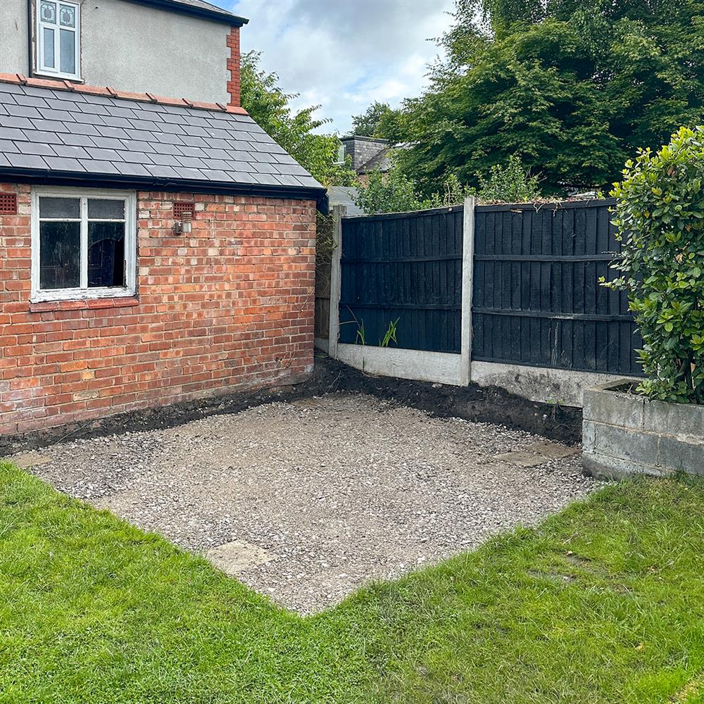 A sub-base of gravel in a lawned garden before patio paving is layed